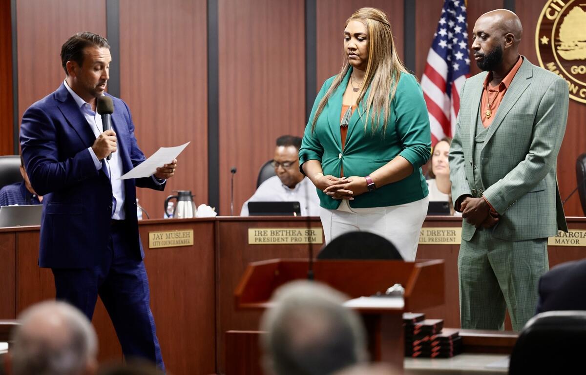 Mayor Marciano reads from a paper as Larry and Darnitha Johnson listen during the meeting.