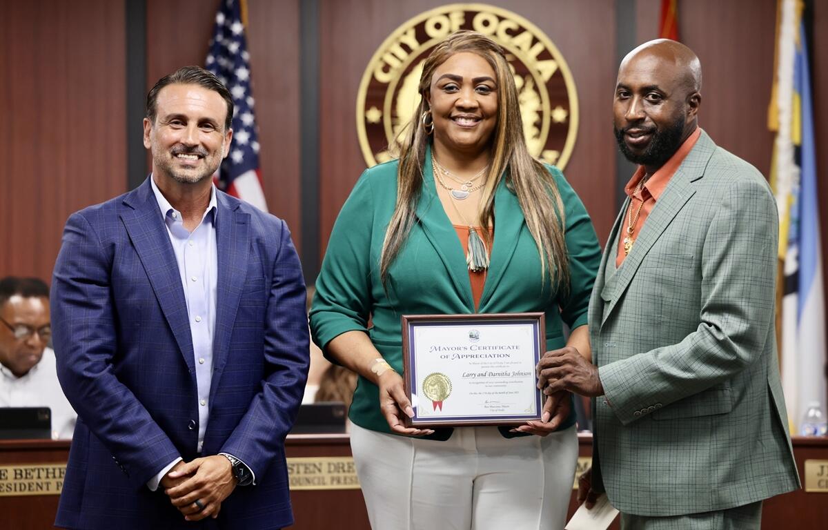 Mayor Marciano stands with Larry and Darnitha Johnson as they hold a framed certificate of recognition.