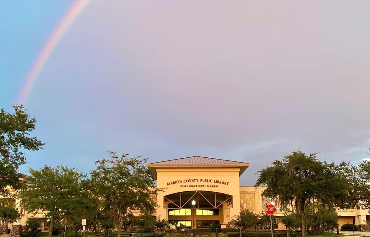 Marion County Public Library Headquarters in Ocala, Florida, with a rainbow in the sky above the building.