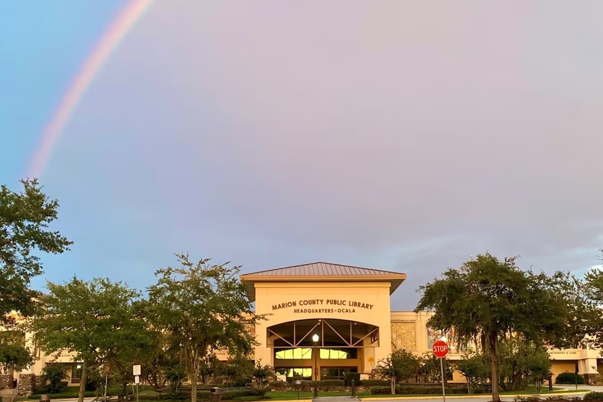 Marion County Public Library Headquarters in Ocala, Florida, with a rainbow in the sky above the building.