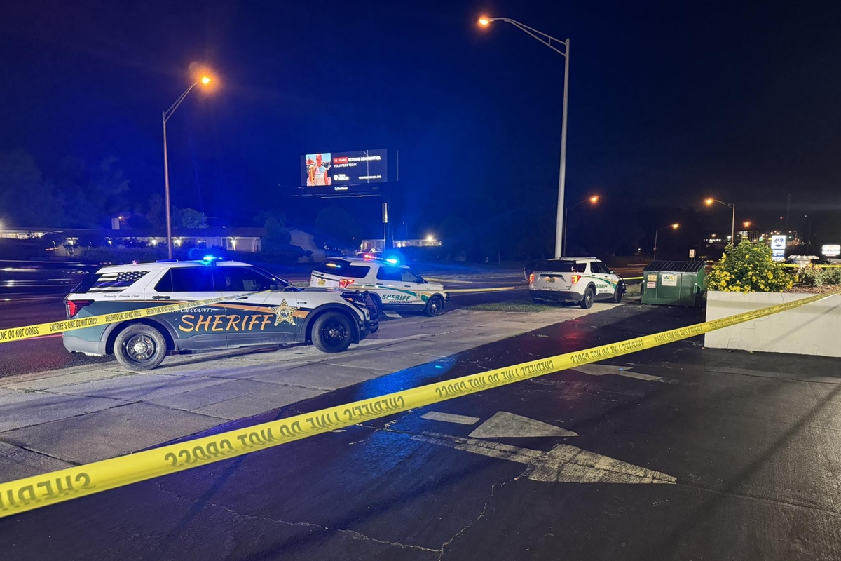 Three Marion County Sheriff's Office patrol vehicles parked at a taped-off crime scene at night with emergency lights flashing.