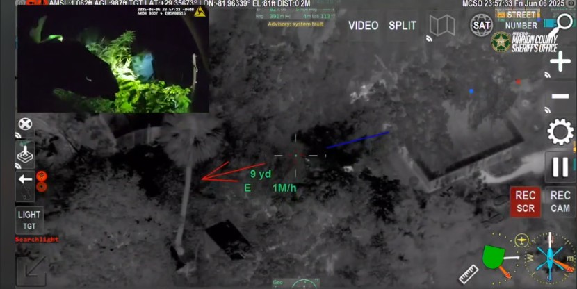 A police helicopter’s infrared camera tracks a suspect moving through a wooded area at night, with tactical overlays and a small inset of ground footage.