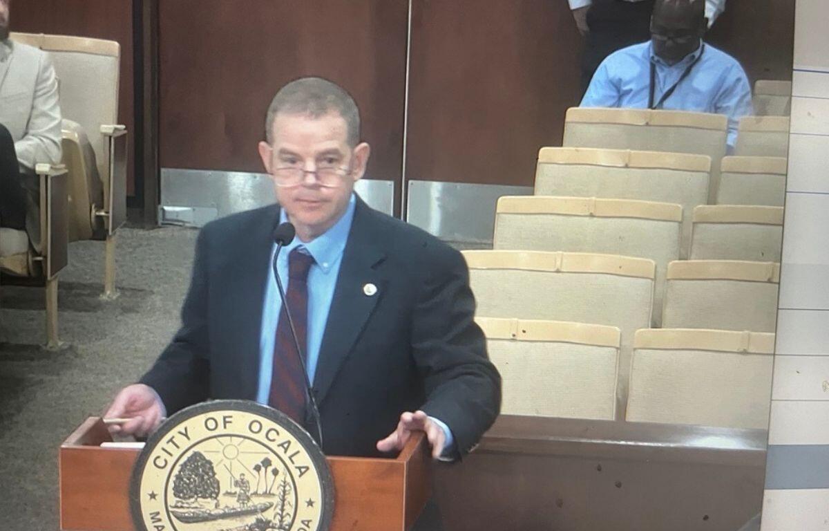 Murray Hamilton of Raftelis Financial Consultants speaks at a podium during the Ocala City Council meeting, presenting the city's updated utility rate study.