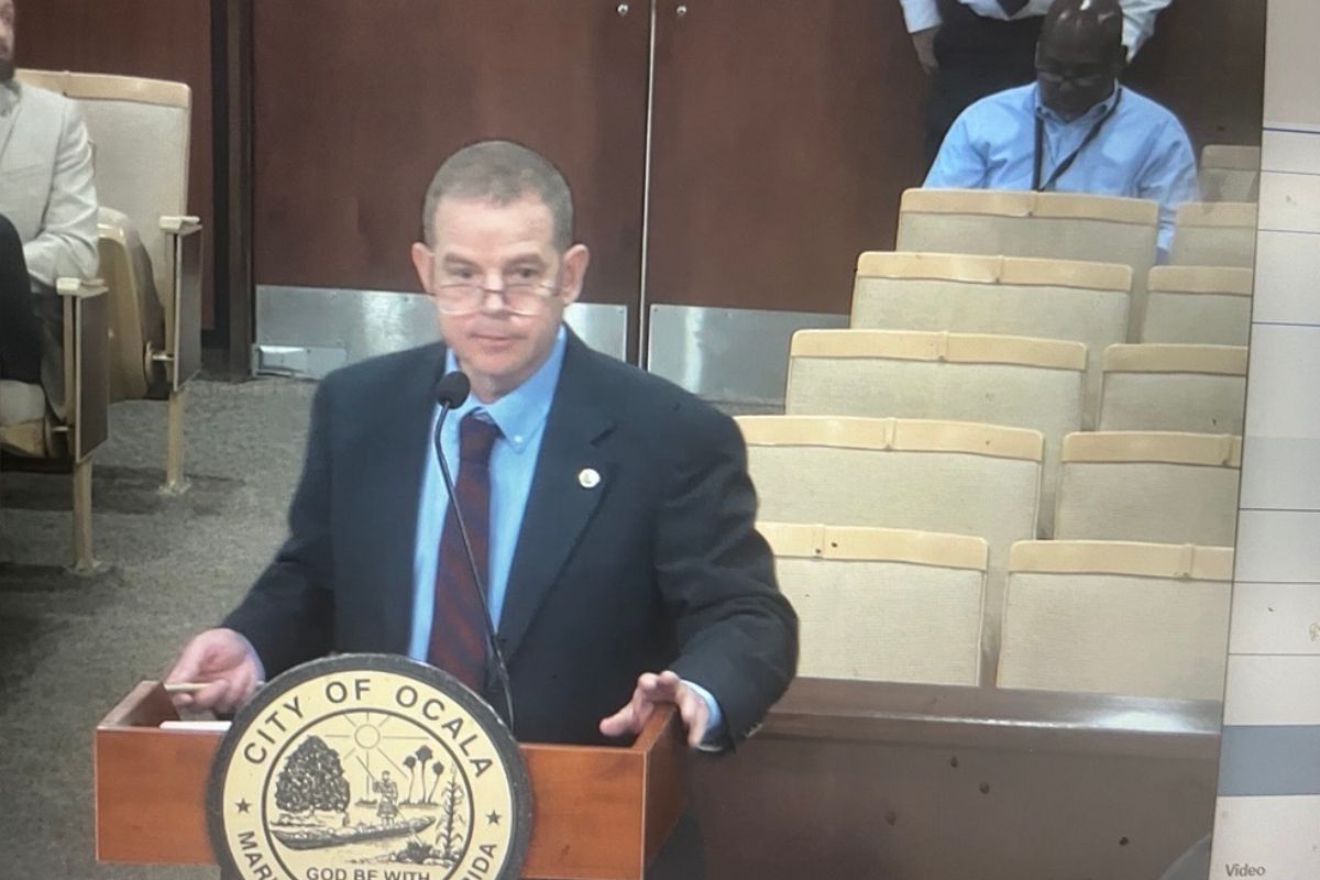 Murray Hamilton of Raftelis Financial Consultants speaks at a podium during the Ocala City Council meeting, presenting the city's updated utility rate study.