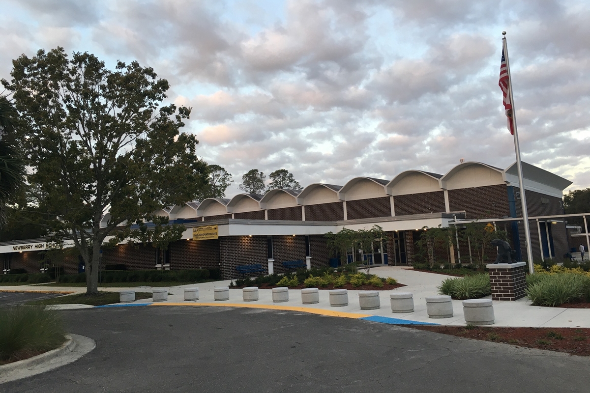 Exterior view of Newberry High School in Newberry, Florida, with American flag and landscaped entrance.