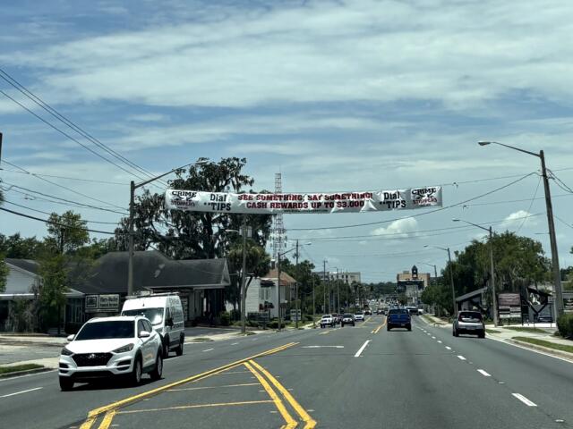 Crime Stoppers banner displayed over East Silver Springs Boulevard in Ocala, Florida, encouraging tips with cash rewards.