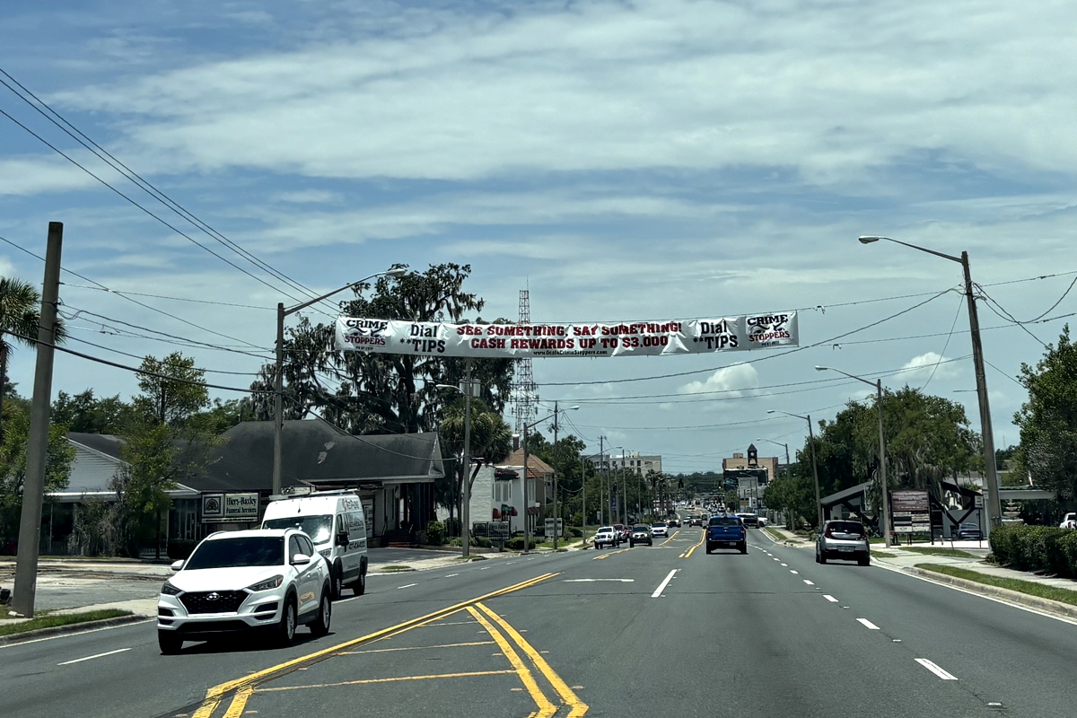 Crime Stoppers banner displayed over East Silver Springs Boulevard in Ocala, Florida, encouraging tips with cash rewards.
