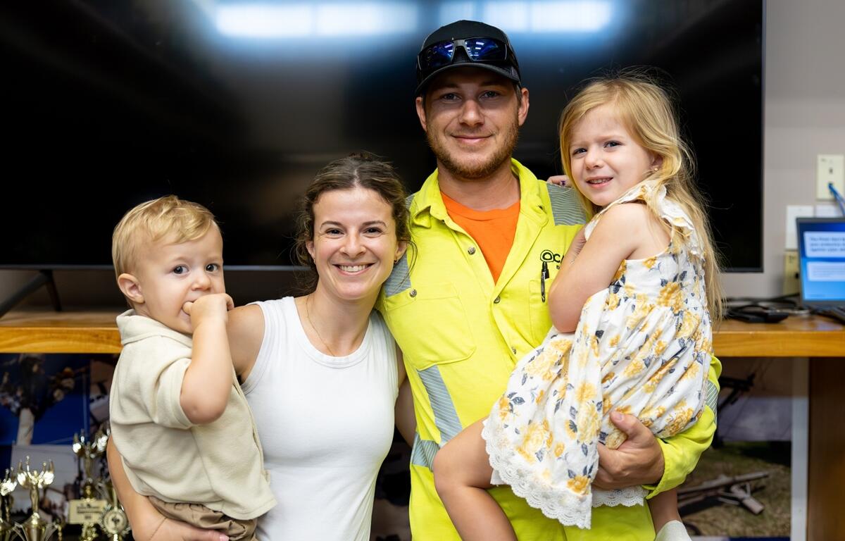 Smiling Ocala Utility Services apprentice Jeremy Retherford poses with his partner and two young children at the June 2025 apprenticeship graduation ceremony.