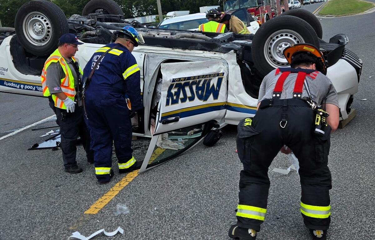 First responders surround an overturned white pickup truck on its roof during a vehicle rescue in Ocala.