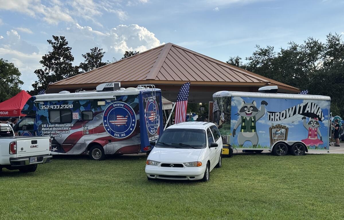 Veterans Helping Veterans and “Throw It Away” trailers parked on grass at PTSD Awareness Walk in Ocala.