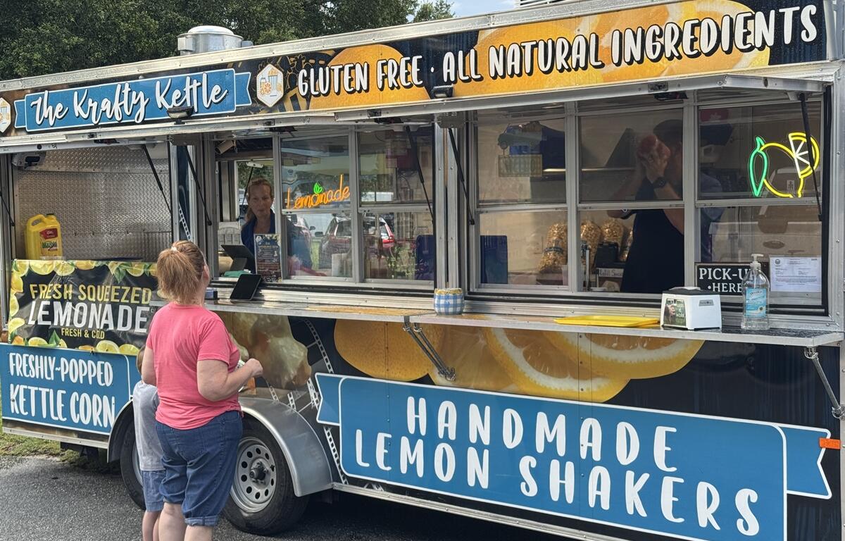 Woman and child order from The Krafty Kettle food truck offering lemonade and kettle corn at the PTSD Awareness Walk.