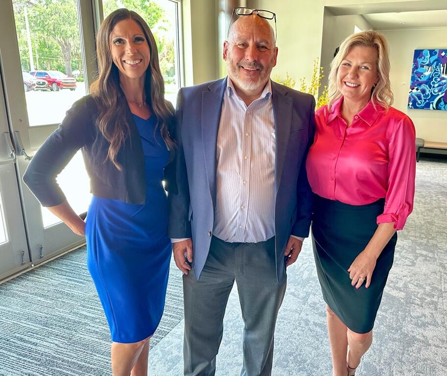 Sara Russell, Pete Lee, and Angie Lewis smiling together at the AdventHealth Mainstage dedication in Ocala.
