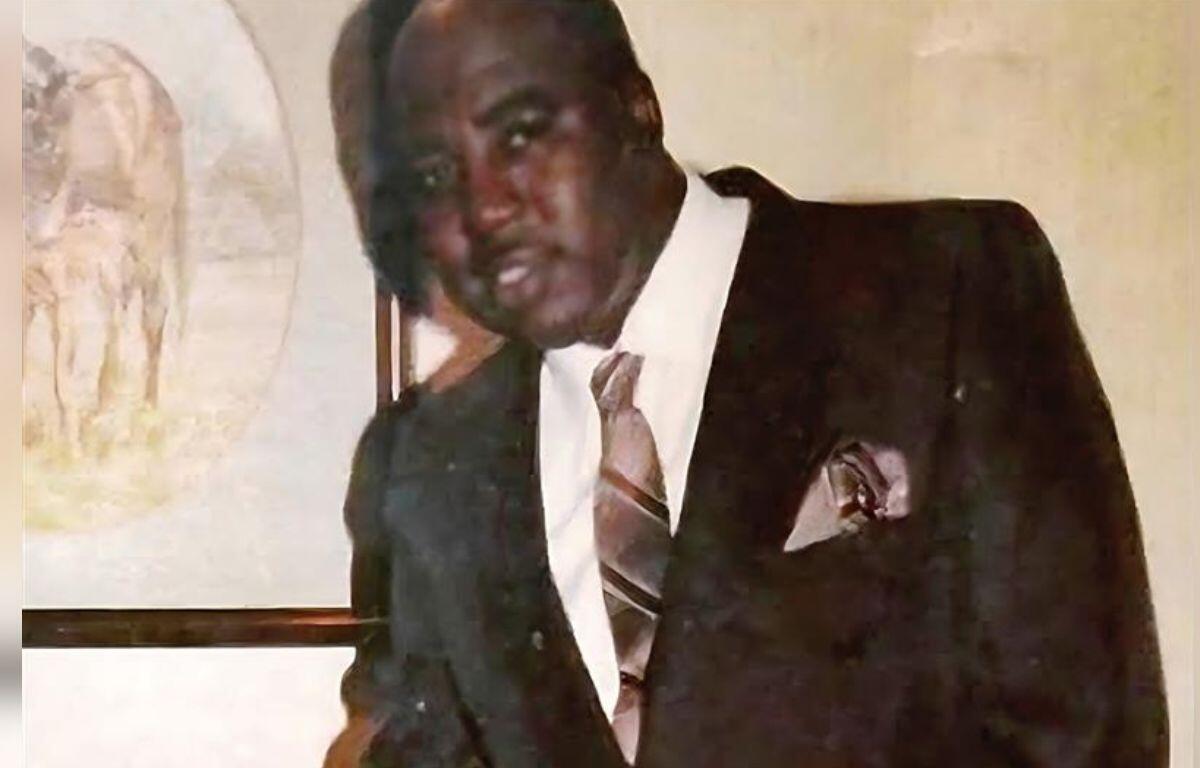 Rev. Leroy Johnson dressed in a suit and tie, standing indoors.