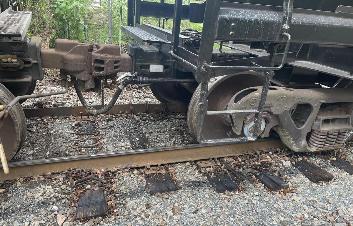 Close-up of derailed CSX train car off the tracks in Ocala, showing wheels misaligned with the rail.