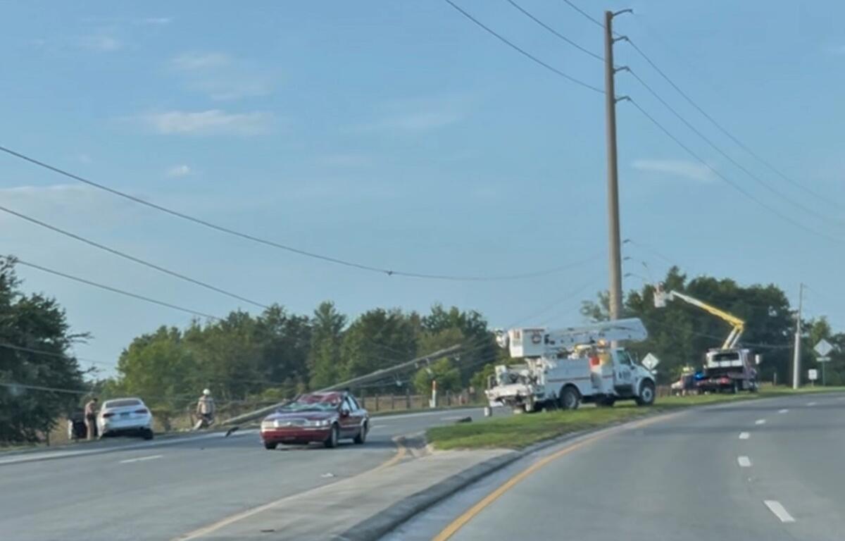 Utility trucks and crews repair downed power lines on SW 60th Avenue in Ocala after a crash.