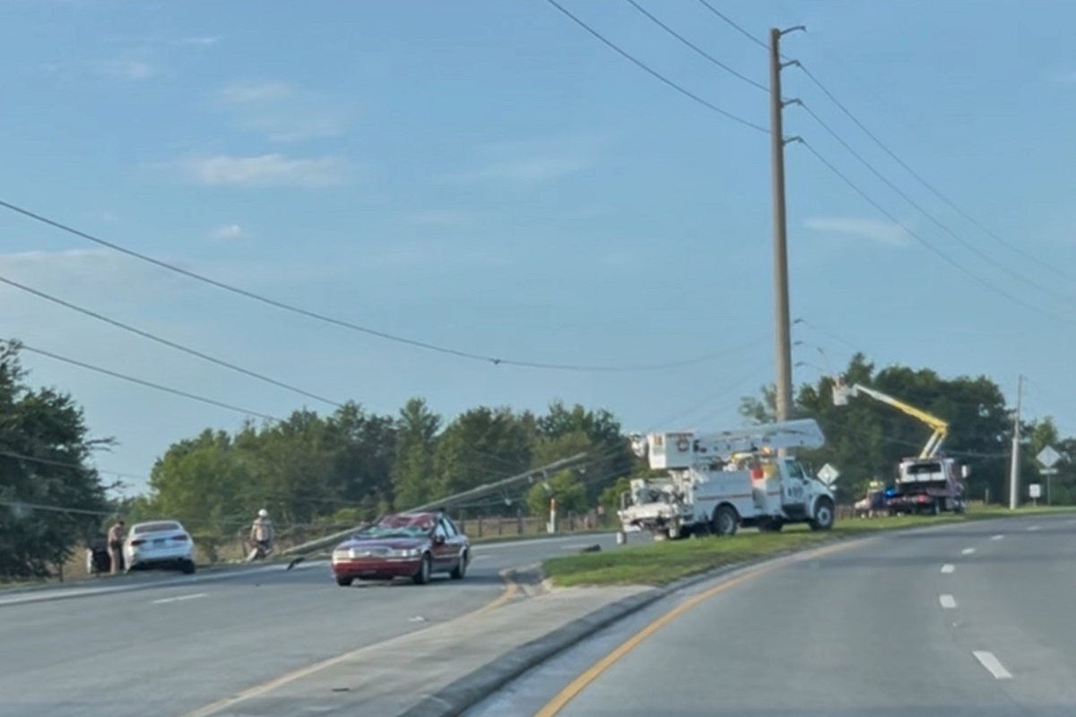 Utility trucks and crews repair downed power lines on SW 60th Avenue in Ocala after a crash.