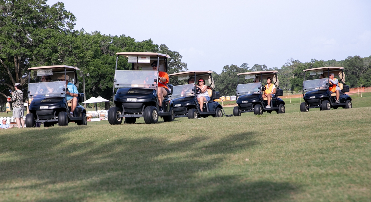 Volunteers drive golf carts across the Ocala Golf Club course, helping guests during Fine Arts for Ocala’s Symphony Under the Stars event.