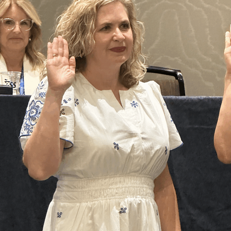 Dr. Allison Campbell raises her right hand while being sworn in as FSBA president-elect at a conference in Tampa.