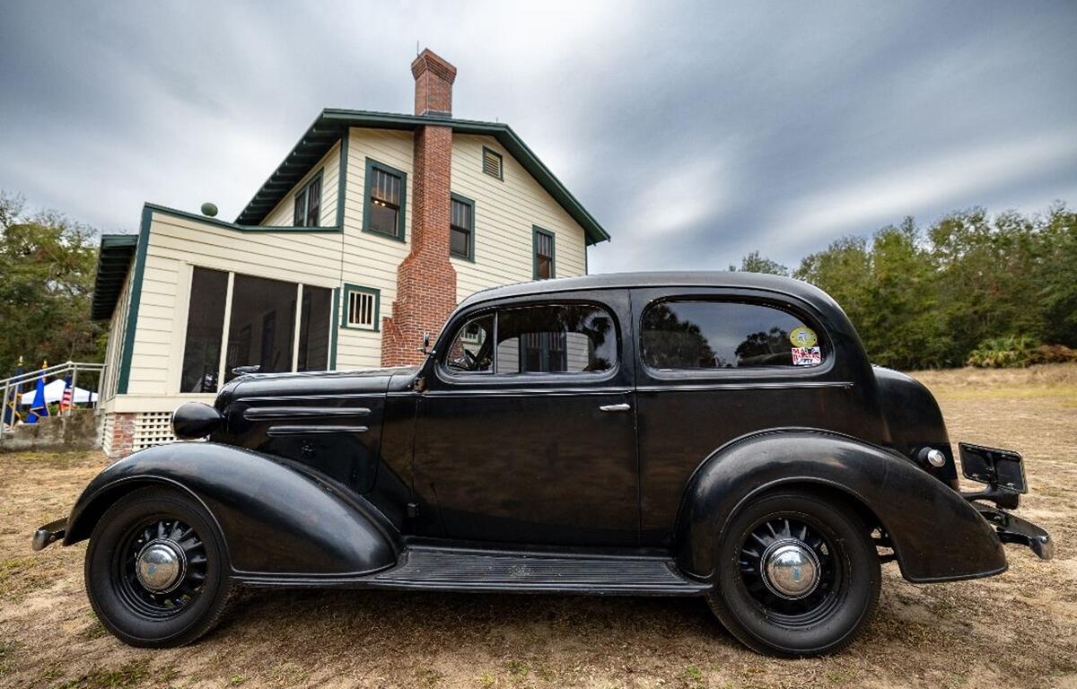 Vintage black car parked outside the historic Ma Barker House in Bradford County, Florida.