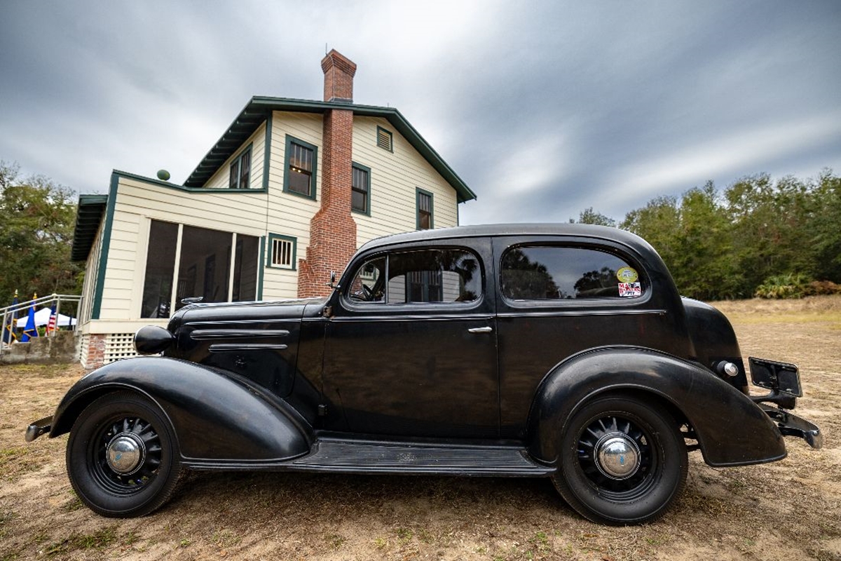 Vintage black car parked outside the historic Ma Barker House in Bradford County, Florida.