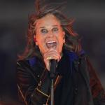 Ozzy Osbourne performs on stage with intense expression, gripping a microphone.