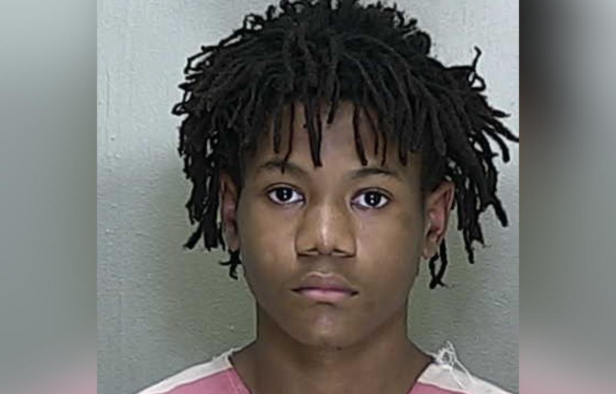 Mugshot of Christopher Atkins, 15, wearing a pink-striped jail uniform.