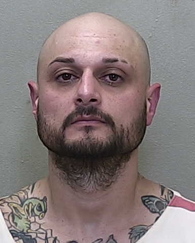 Mugshot of Christopher Obregon in jail uniform with visible tattoos