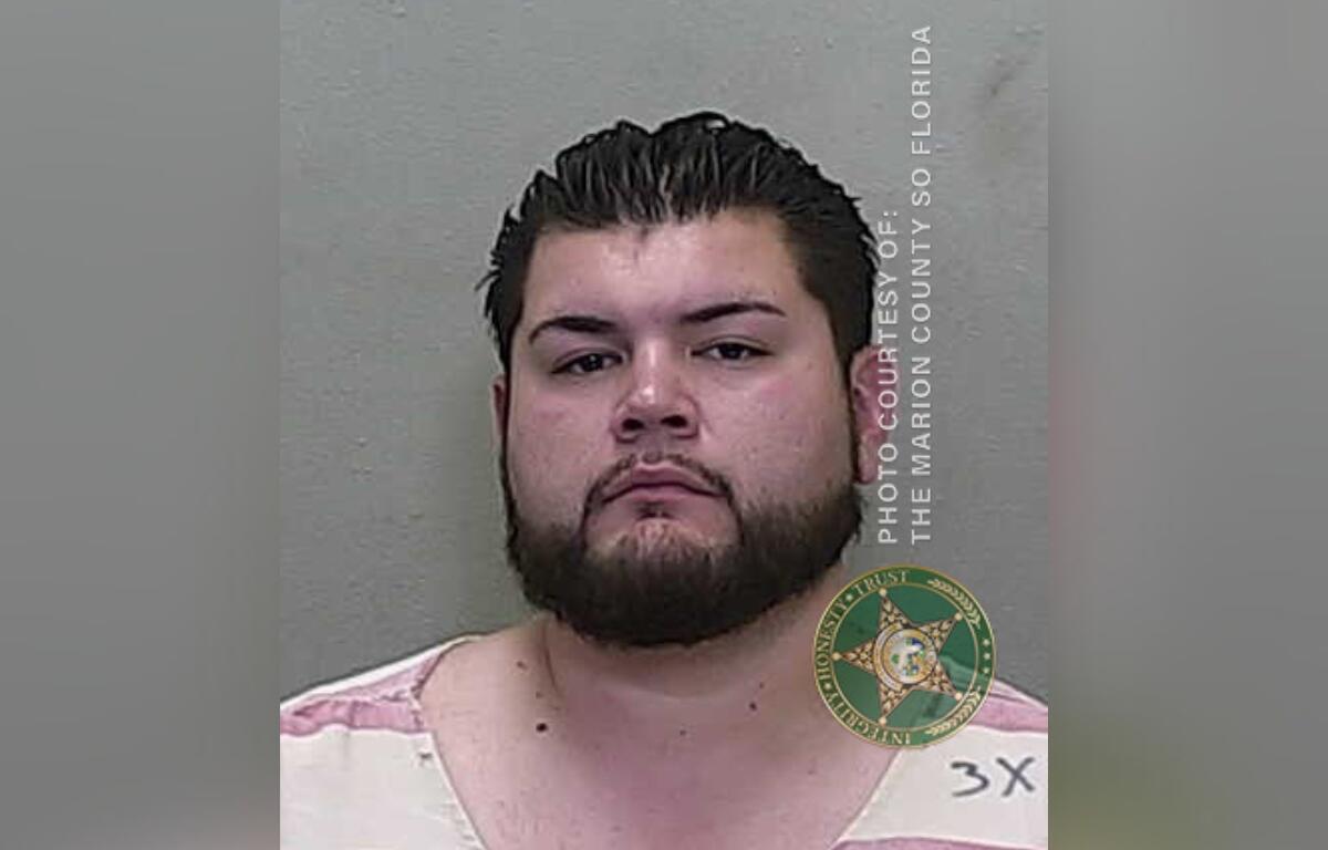 Mugshot of Christopher Rivera, a 30-year-old man with dark hair and a beard, wearing a pink and white striped shirt, taken by the Marion County Sheriff's Office.