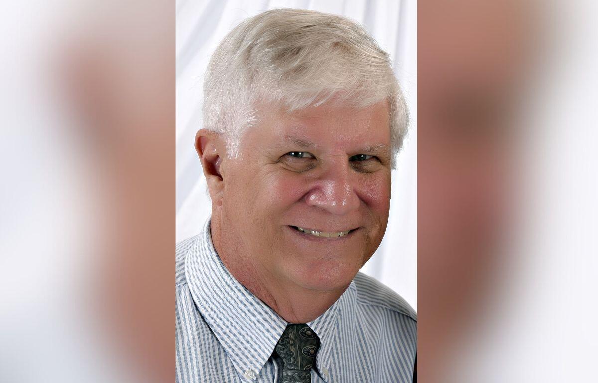 A picture of a man in a dress shirt wearing a tie against a white background.