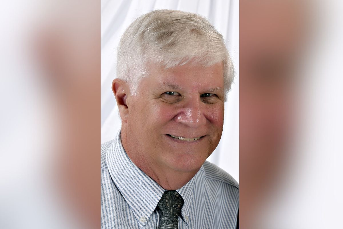 A picture of a man in a dress shirt wearing a tie against a white background.
