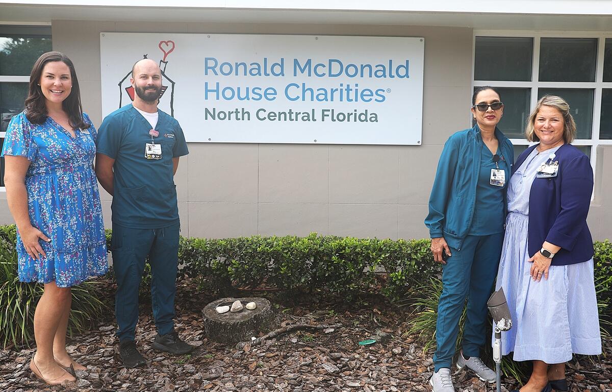 Four people standing outside Ronald McDonald House Charities of North Central Florida in Gainesville.
