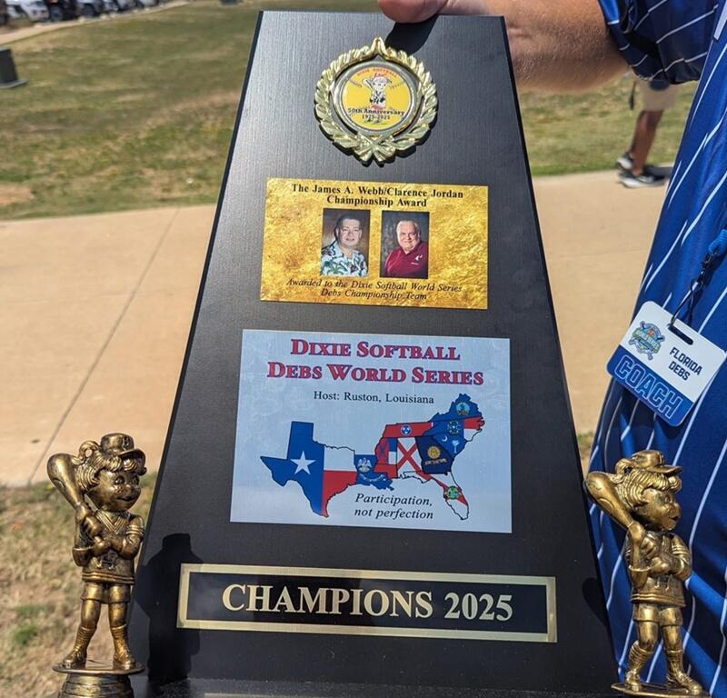 A coach holds the championship trophy awarded to the Belleview 19u Dixie Debs after winning the 2025 Dixie Softball World Series in Ruston, Louisiana.