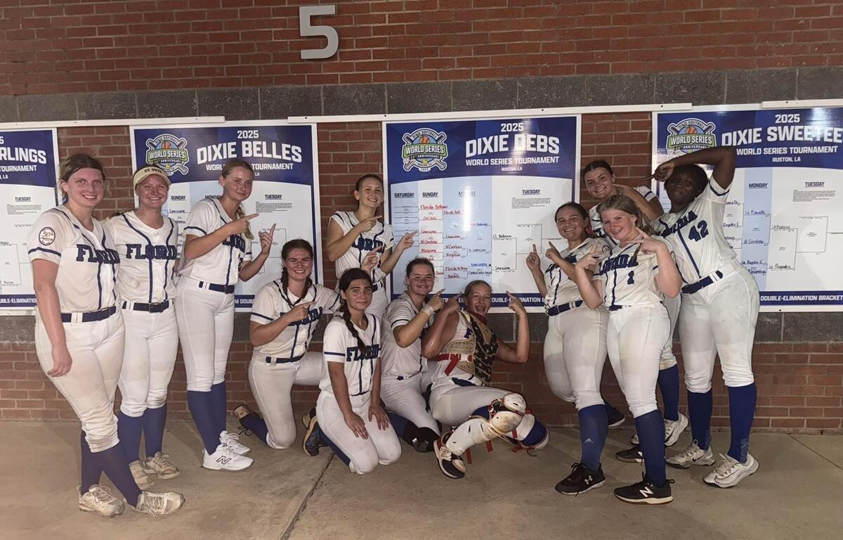 Belleview 19u Dixie Debs softball players in uniform celebrate by pointing at the completed World Series tournament bracket showing their path to victory.