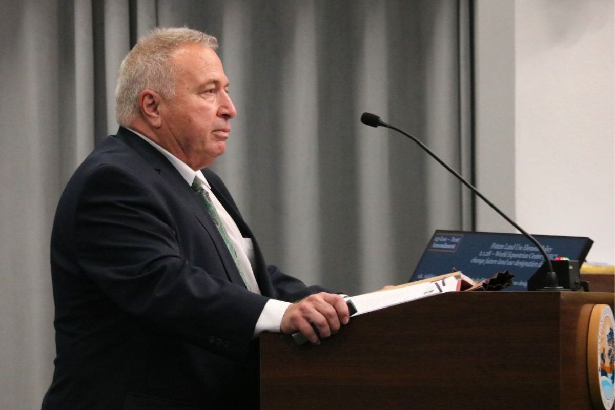 Jimmy Gooding III speaks at a podium during a county commission meeting.