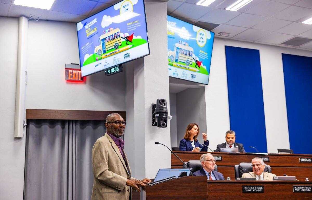 Thomas Butler presents at a county commission meeting in Ocala to support the Bus Brigade school supply drive.