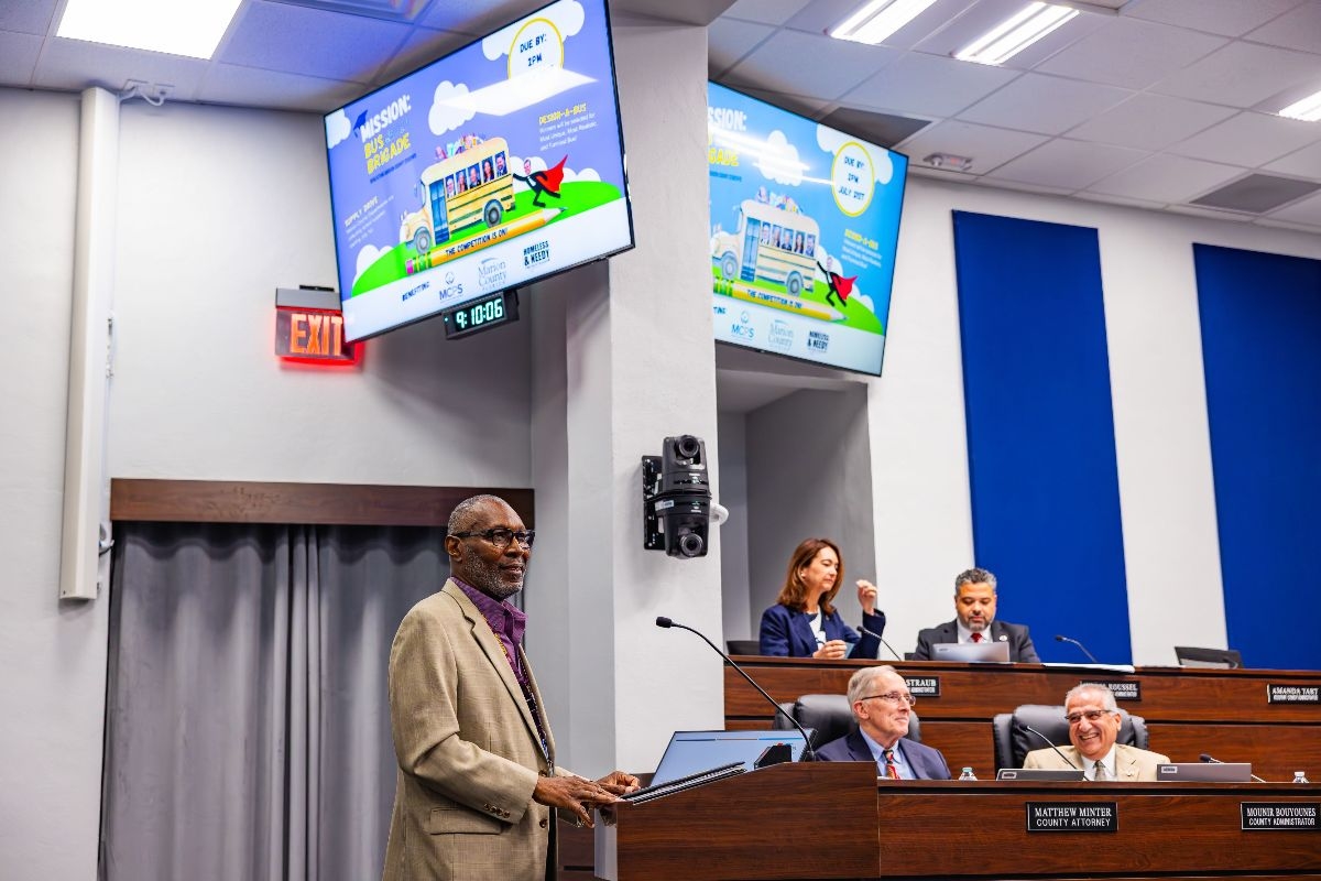 Thomas Butler presents at a county commission meeting in Ocala to support the Bus Brigade school supply drive.