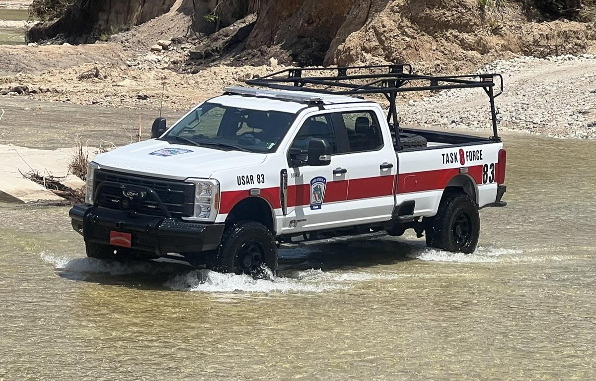 Task Force 8 rescue truck driving through shallow floodwaters in Kerr County, Texas