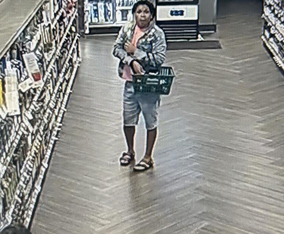 Surveillance image of a man holding a shopping basket inside a liquor store.