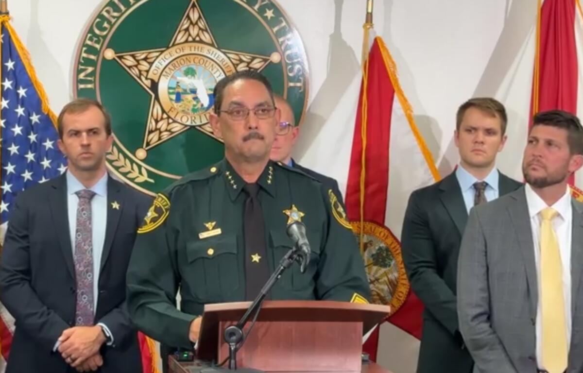 Sheriff Billy Woods speaks at a press conference with law enforcement officials standing behind him.