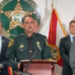 Sheriff Billy Woods speaks at a press conference with law enforcement officials standing behind him.