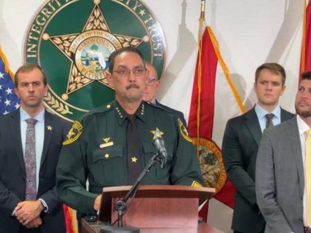 Sheriff Billy Woods speaks at a press conference with law enforcement officials standing behind him.