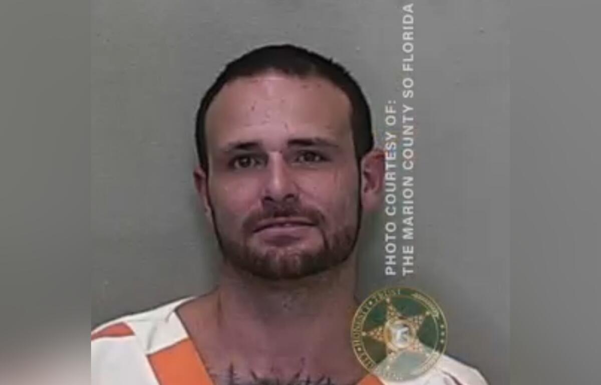 Mugshot of Michael Bailey wearing a white and orange jail uniform.