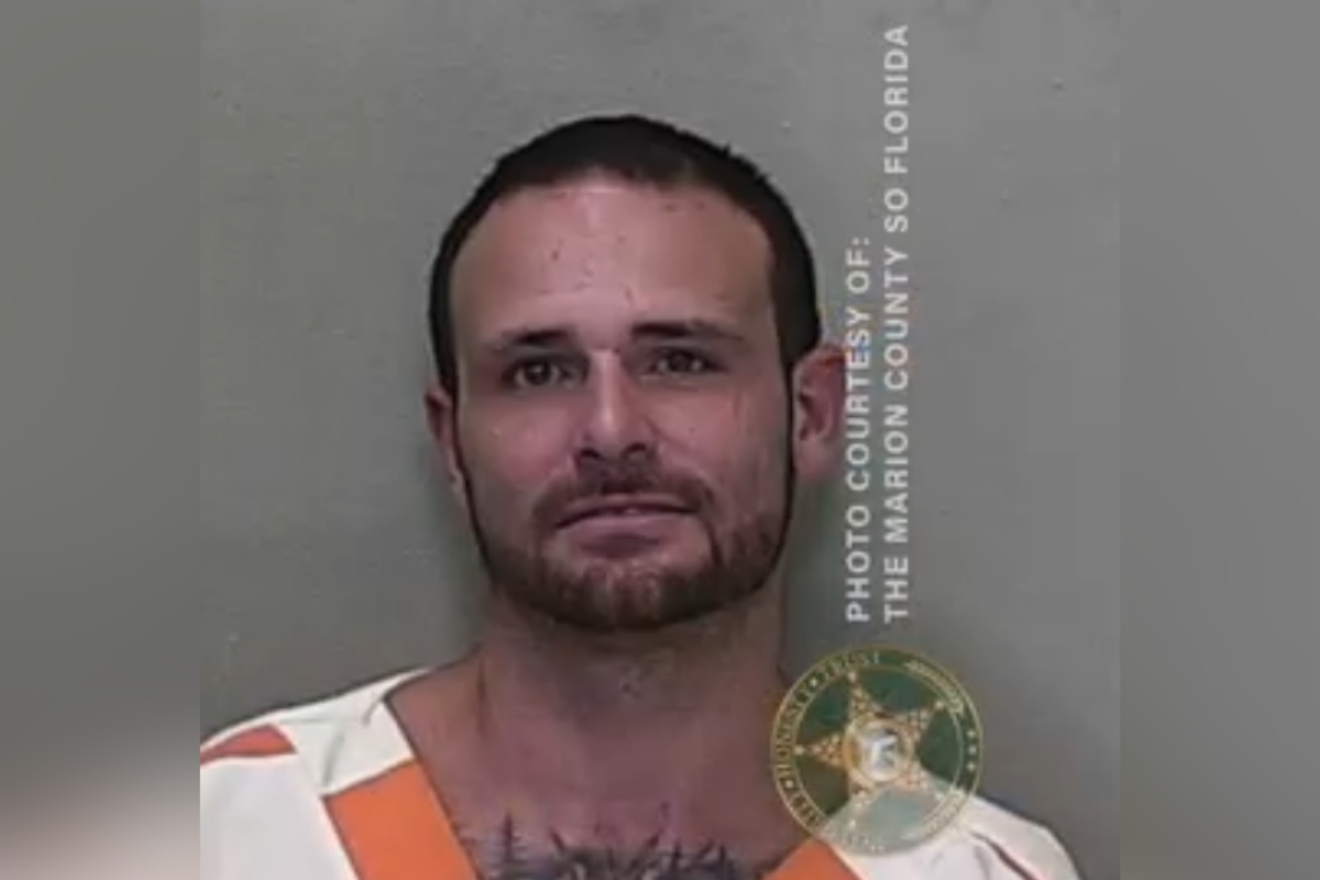 Mugshot of Michael Bailey wearing a white and orange jail uniform.