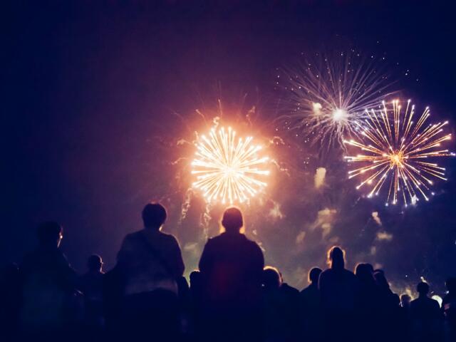 Crowd watching fireworks light up the night sky at Tavares July 4th event.