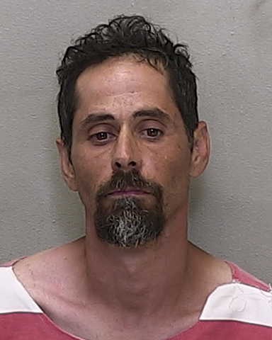 Booking photo of Noel Barboza wearing a red and white striped jail uniform.