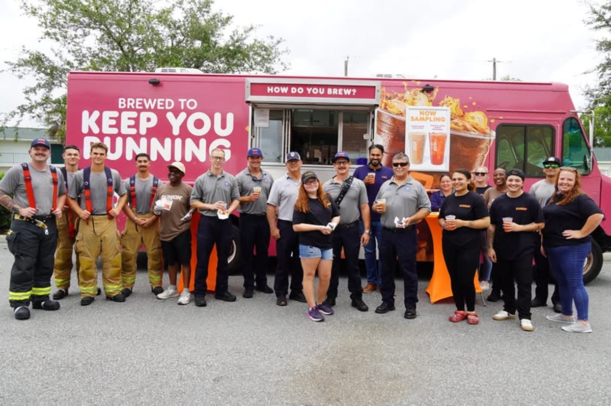 Ocala firefighters and Dunkin’ employees pose in front of the Dunkin’ Community Cruiser with drinks and treats.
