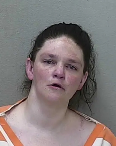 Booking photo of Sarah Gore wearing a striped jail uniform.