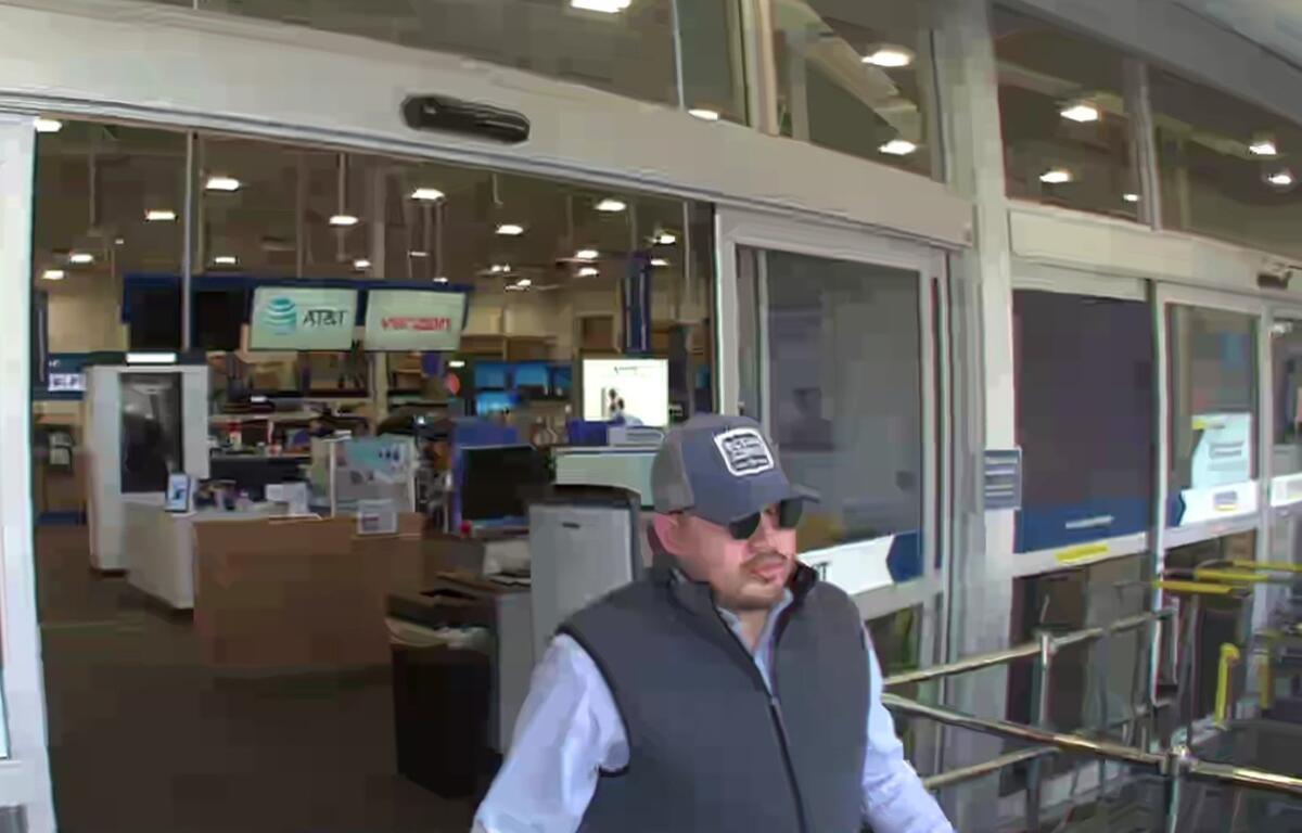 Man in sunglasses and a gray hat exits Best Buy in Ocala after suspected credit card fraud.