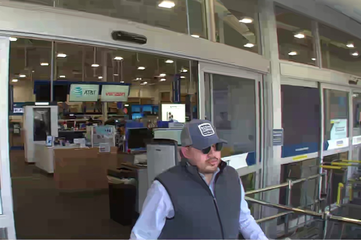 Man in sunglasses and a gray hat exits Best Buy in Ocala after suspected credit card fraud.