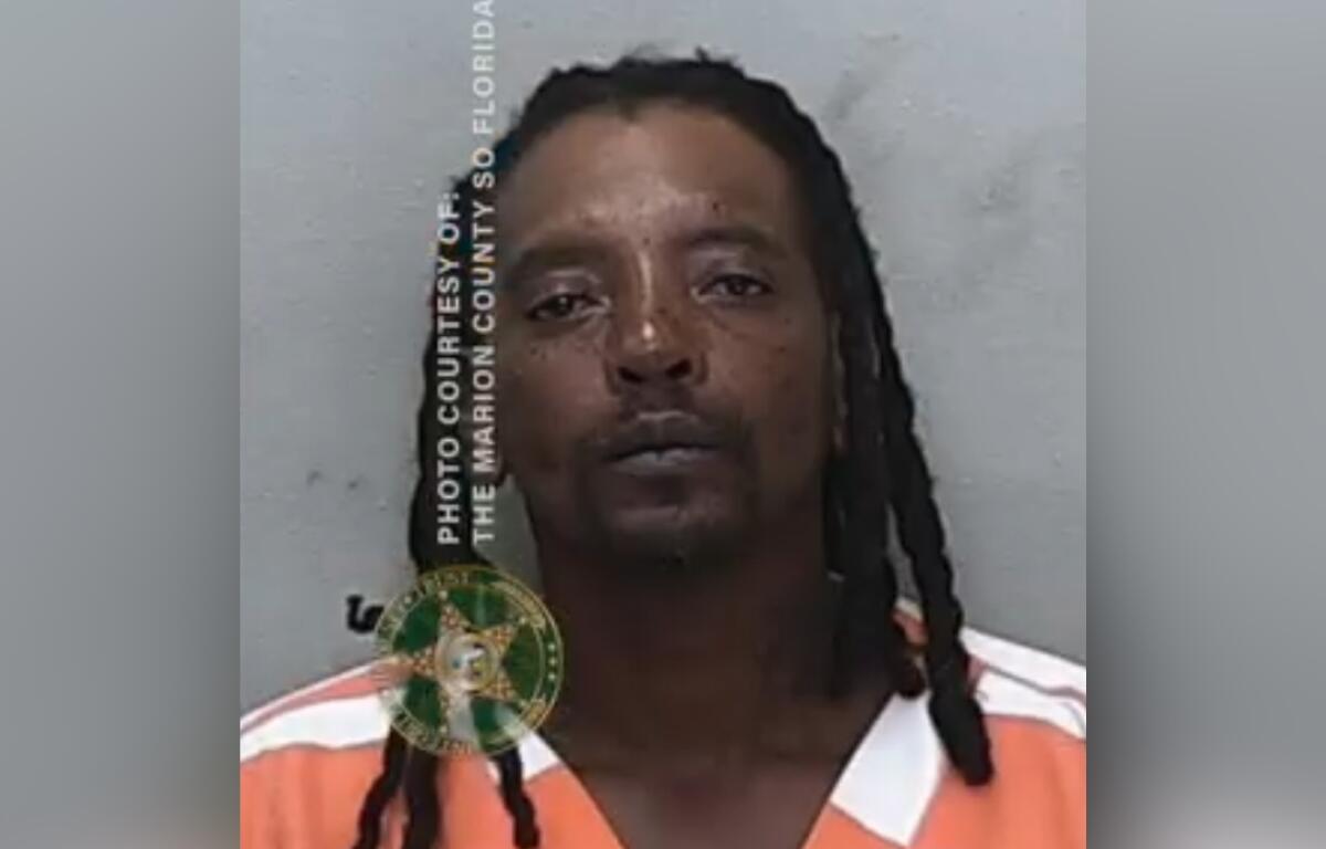Booking photo of Clifford Shells wearing an orange and white jail uniform.
